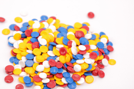 Colorful plastic polymer granules on whiteの写真素材