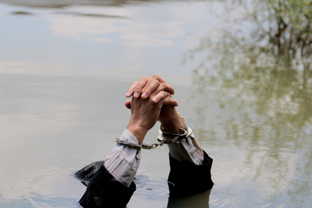 Businessman handcuffed by drowning.の写真素材