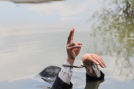Businessmen put their hands up and he was holding two fingers in the river.の写真素材