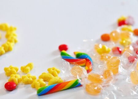 Sweets scattered on the table: caramel, Breakfast cereals on a white backgroundの写真素材