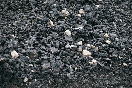 Crushed asphalt with a large fraction of black with crushed stone close-up, macro