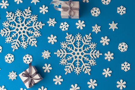 Christmas festive blue background, with a beautiful pattern of white snowflakes of different sizes, similar to a frosty patternの写真素材