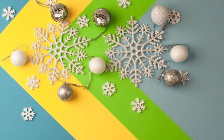 Christmas background of multicolored paper with a graphic pattern, with snowflakes, Christmas decorations and wooden toys.の写真素材
