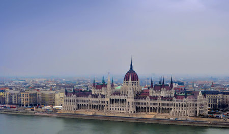 View on the Parliament of Budapest, river Danube and nearby houses on a winter dayの写真素材