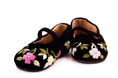 Decorative little girl shoes on isolated white backgroundの写真素材