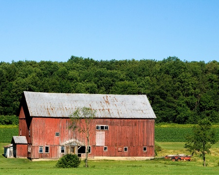 old barn, with metal roof, in the countryside on a sunny day with a clear blue sky