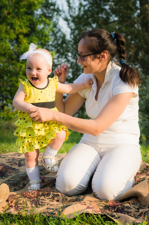 mother and daughter having fun on the green grassの写真素材
