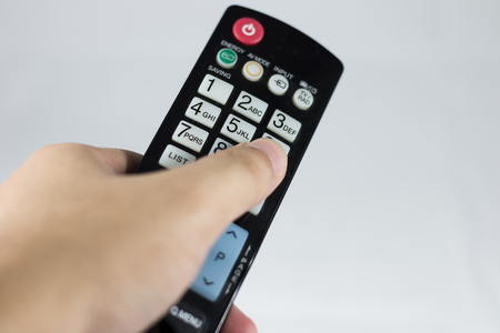 The remote control on hand for change channel の写真素材