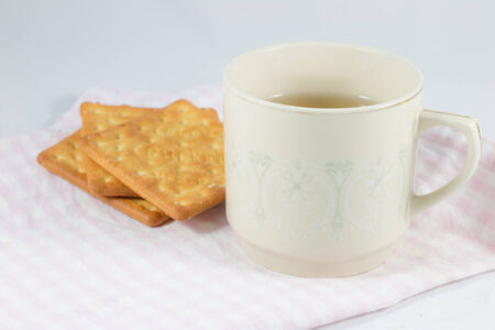 A cup of tea with crakers.の写真素材