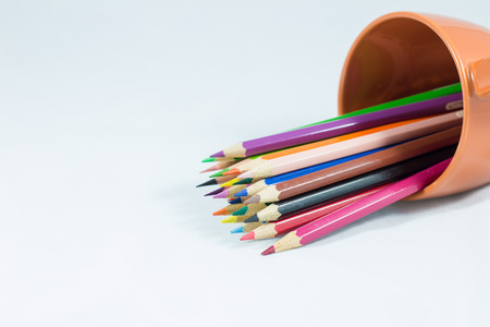 Color pencil in coffee cup on the white background.の写真素材