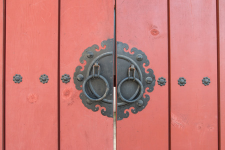 Korean vintage door knob on red door.の写真素材
