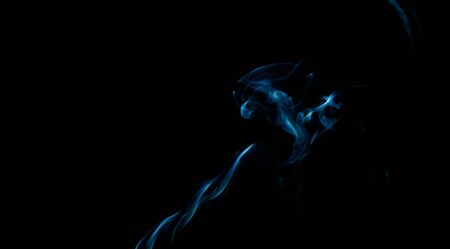 Abstract blue smoke swirls over black backgroundの写真素材