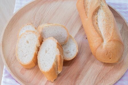 Sliced french bread baguette on wooden plateの写真素材