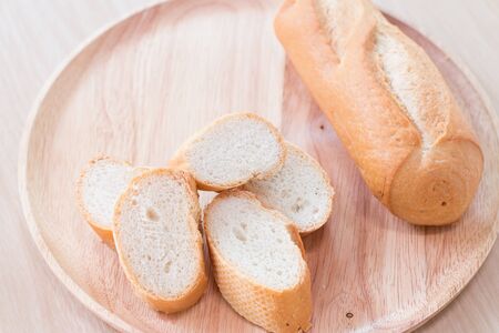 Sliced french bread baguette on wooden plate.Soft focus styleの写真素材