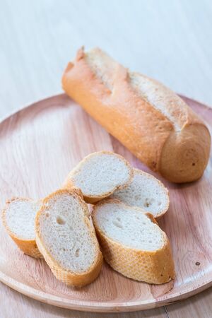 Sliced french bread baguette on wooden plate.Soft focus styleの写真素材