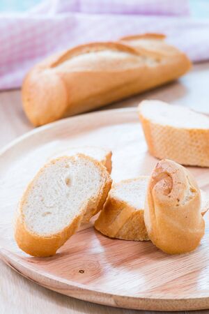 Sliced french bread baguette on wooden plate.Soft focus styleの写真素材