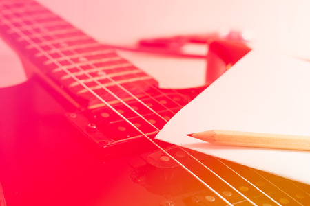 Pencil and paper on guitar with color filter.の写真素材