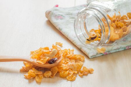 Caramel cornflake in spoon on wooden table,Selective focus on cashew nut.