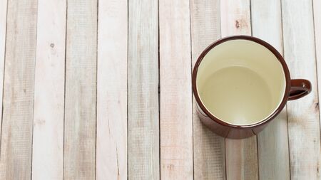 Empty vintage cup on wooden background.
