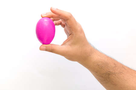 Pink egg on hand on white background for easter day.の写真素材