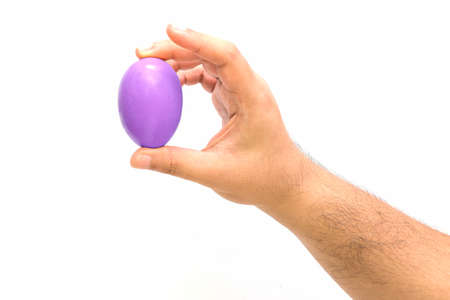Purple egg on hand on white background for Easter day.の写真素材