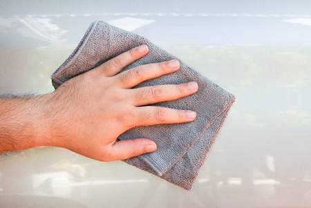Cleaning car with microfiber cloth by a man's hand.の写真素材