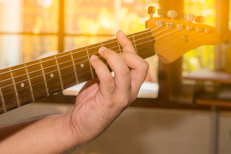 Boys hand with a guitar.