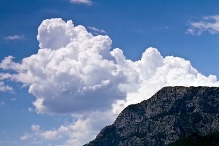 a large white cloud over the mountainの写真素材