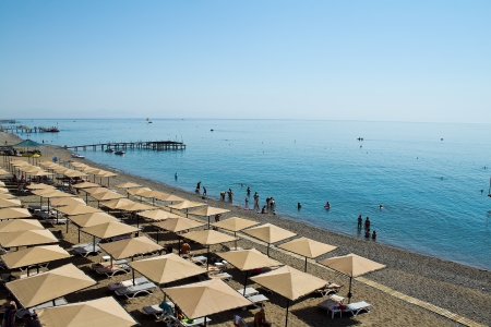 Tourists rest in the shade of a beach umbrella on the beachのeditorial素材