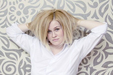 A young woman with dishevelled hair and expressive eyesの写真素材