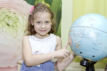 Little girl showing country on the globeの写真素材