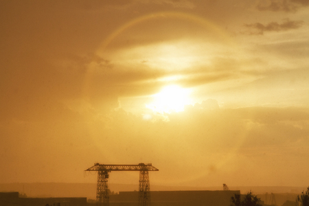 The sun at sunset through the clouds glaresの写真素材