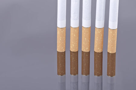 Cigarette on a reflective surfaceの写真素材