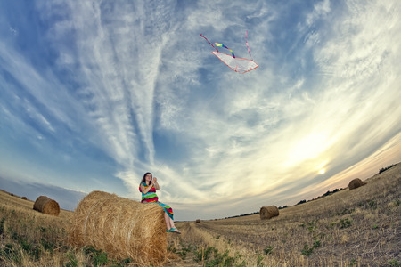 Young pregnant woman starts flying serpent in the fieldの写真素材