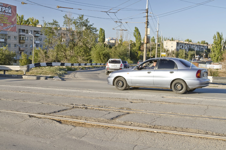 VOLGOGRAD - SEPTEMBER 19: Traffic along the asphalt road littered with various holes and dips. September 19, 2014 in Volgograd, Russia.のeditorial素材