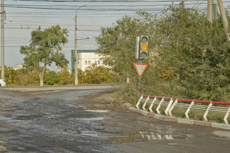 VOLGOGRAD - SEPTEMBER 24: The terrible condition of the asphalt road surface cracks, potholes and ruts all over the surface.  September 24, 2014 in Volgograd, Russia.のeditorial素材