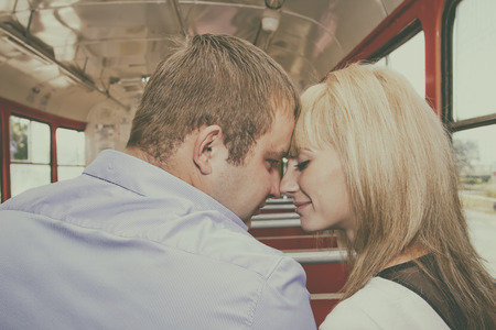 A young couple in love rides the tram on the same seatの写真素材