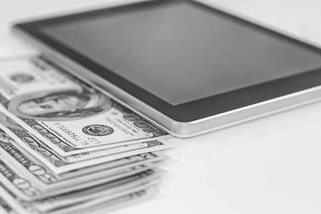 Tablet-PC and dollars on white backgroundの写真素材