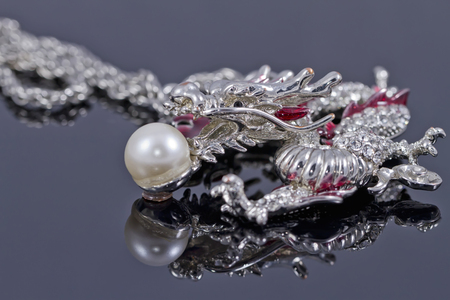 Pendant in the shape of a dragon with a pearl in its mouthの写真素材