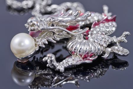 Pendant in the shape of a dragon with a pearl in its mouthの写真素材