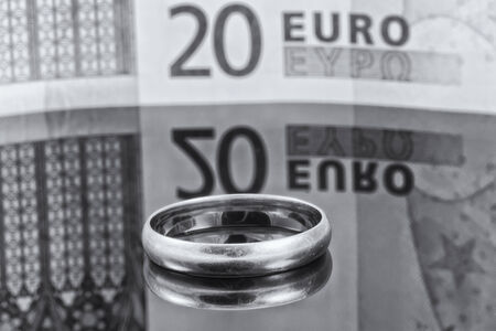 Gold ring on background of Euro banknotes with reflectionの写真素材