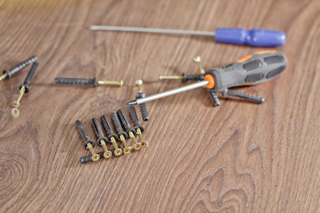 screws and screwdriver lying on the floorの写真素材