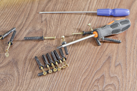 screws and screwdriver lying on the floorの写真素材