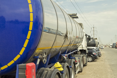truck with a tank for the transport of petroleum products is on the paved lot in the industrial zoneの写真素材