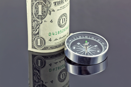 dollar bill and compass are on the surfaceの写真素材