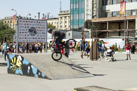 VOLGOGRAD - MAY 24: The athlete is an extreme sports enthusiast performs a trick on a BMX bike with a rotation on the front wheel. The fifth annual competition for the Cup of Europe city Mall . May 24, 2015 in Volgograd, Russia.のeditorial素材