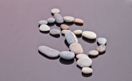 The dollar sign is fine going out of small sea stones on the reflecting surfaceの写真素材