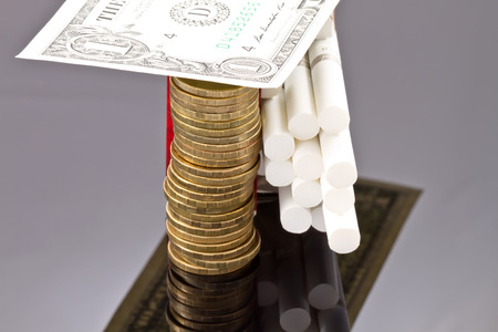 Open pack of cigarettes, coins and dollar billsの写真素材