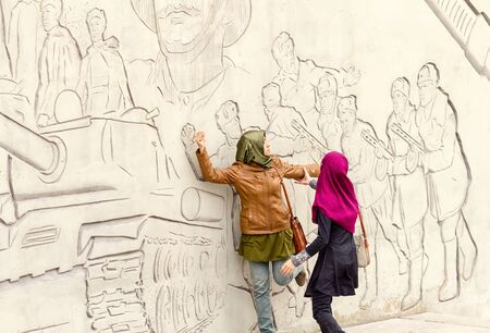 VOLGOGRAD - SEPTEMBER 28:Tourists from Asia pose in front of figures describing feats of Russian...