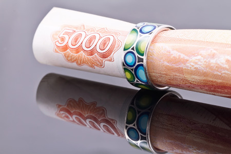 Silver ring with colored enamel put on a banknote 5000 rublesの写真素材